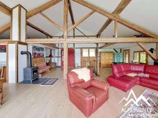 Discover the charm of this stunning property, featuring a spacious living area with exposed wooden beams and a cozy fireplace.
