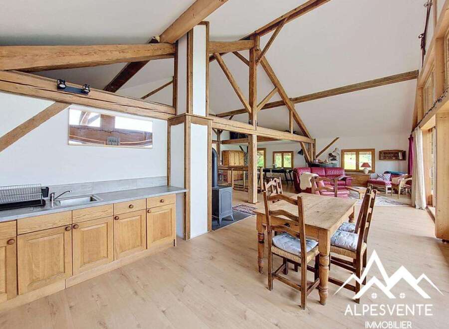 This stunning property boasts a spacious open-plan living area with exposed wooden beams, creating a warm and inviting atmosphere.