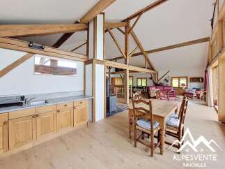 This stunning property boasts a spacious open-plan living area with exposed wooden beams, creating a warm and inviting atmosphere.