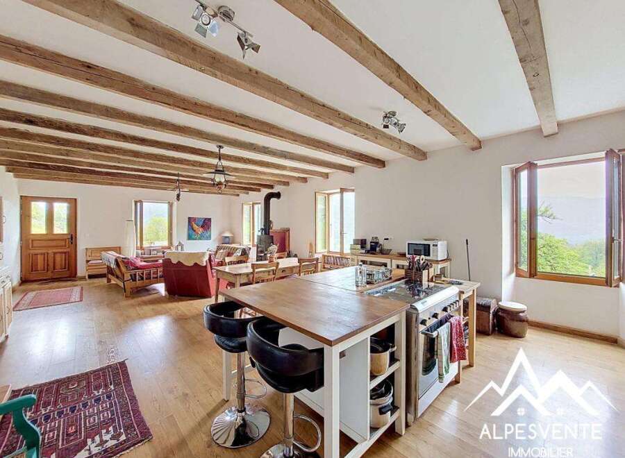 Discover the charm of this stunning property, featuring a spacious open-plan living area with exposed wooden beams and a modern kitchen island.