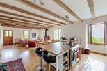 Discover the charm of this stunning property, featuring a spacious open-plan living area with exposed wooden beams and a modern kitchen island.