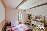 Discover the charm of this cozy bedroom, featuring rustic wooden beams and a warm, inviting atmosphere.