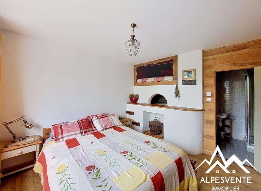 Discover the charm of this unique bedroom featuring a cozy fireplace and rustic wooden accents.