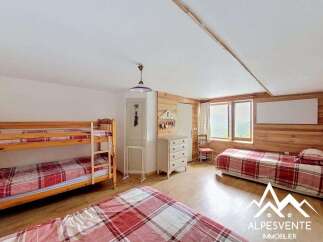 This charming bedroom features a cozy bunk bed and a comfortable single bed, perfect for accommodating guests or family.