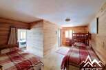 Discover this charming bedroom featuring rustic wooden walls and cozy bedding.