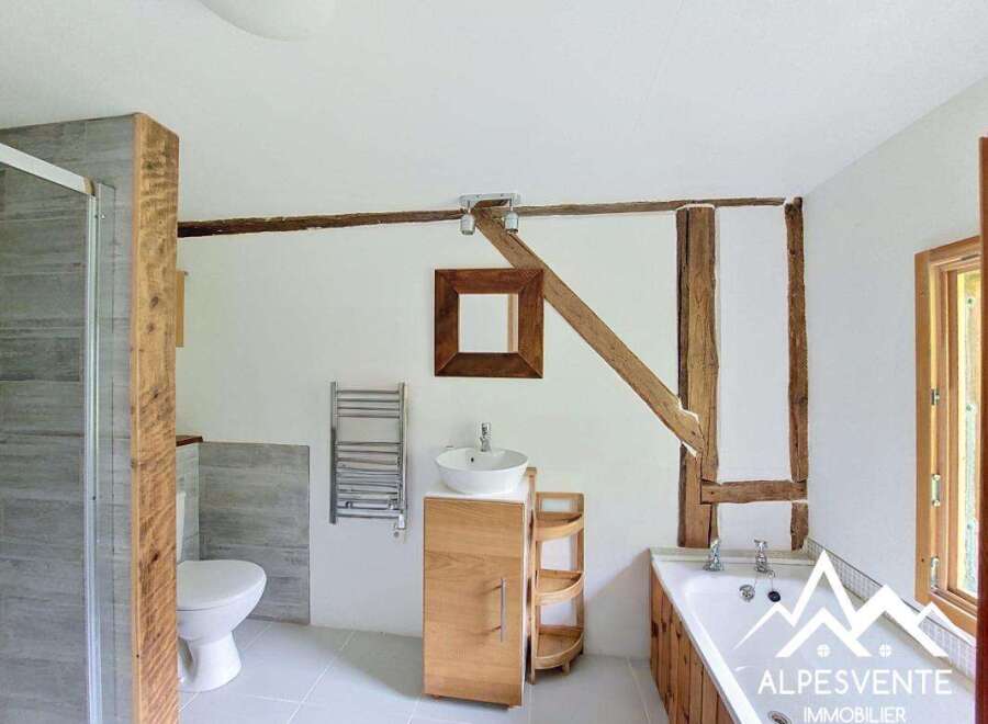 Discover the charm of this unique bathroom, featuring exposed wooden beams and a modern design.