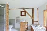 Discover the charm of this unique bathroom, featuring exposed wooden beams and a modern design.
