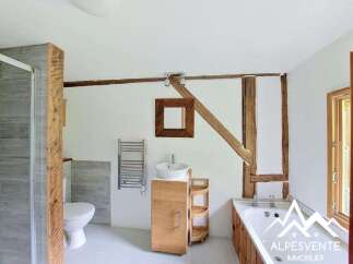 Discover the charm of this unique bathroom, featuring exposed wooden beams and a modern design.
