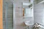 This modern bathroom features a sleek design with gray tiled walls and a glass shower enclosure.