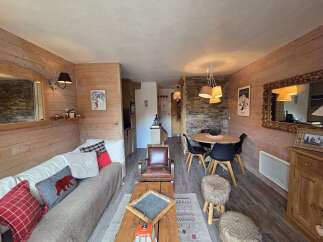 This cozy living space features a rustic design with wooden paneling and a warm ambiance.