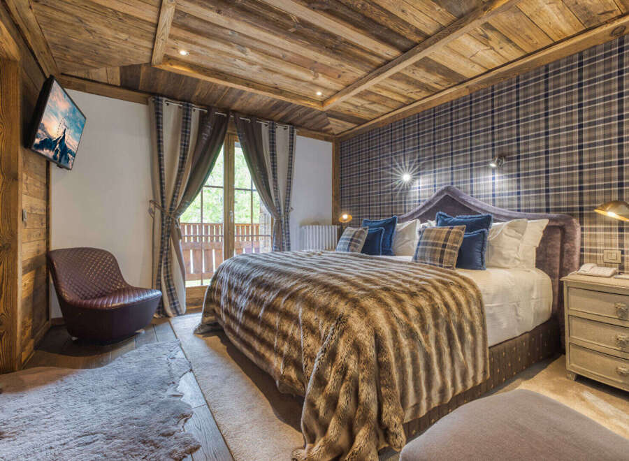 Experience luxury in this exquisite bedroom featuring a cozy, fur-like blanket and a plush, upholstered headboard.