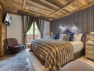 Experience luxury in this exquisite bedroom featuring a cozy, fur-like blanket and a plush, upholstered headboard.