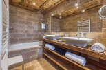 Experience rustic luxury in this stunning bathroom, featuring a deep soaking tub and a spacious walk-in shower with travertine tile accents.