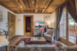 Experience rustic charm in this beautifully appointed living room, featuring a stunning wood-paneled ceiling and walls that exude warmth and alpine elegance.