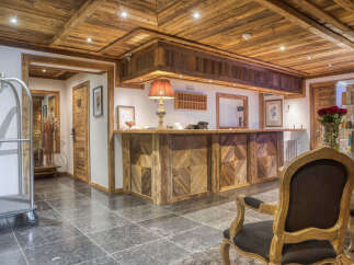Experience rustic charm in this hotel lobby, featuring a stunning wooden reception desk with intricate geometric patterns.