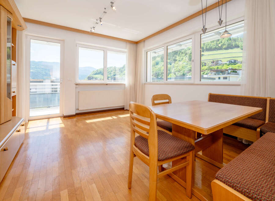 This bright and airy dining area features a beautiful wooden table and chairs, perfect for enjoying meals with family and friends.