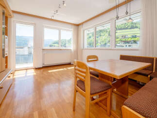 This bright and airy dining area features a beautiful wooden table and chairs, perfect for enjoying meals with family and friends.