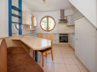 This charming kitchen features a unique design with a round window offering scenic views.