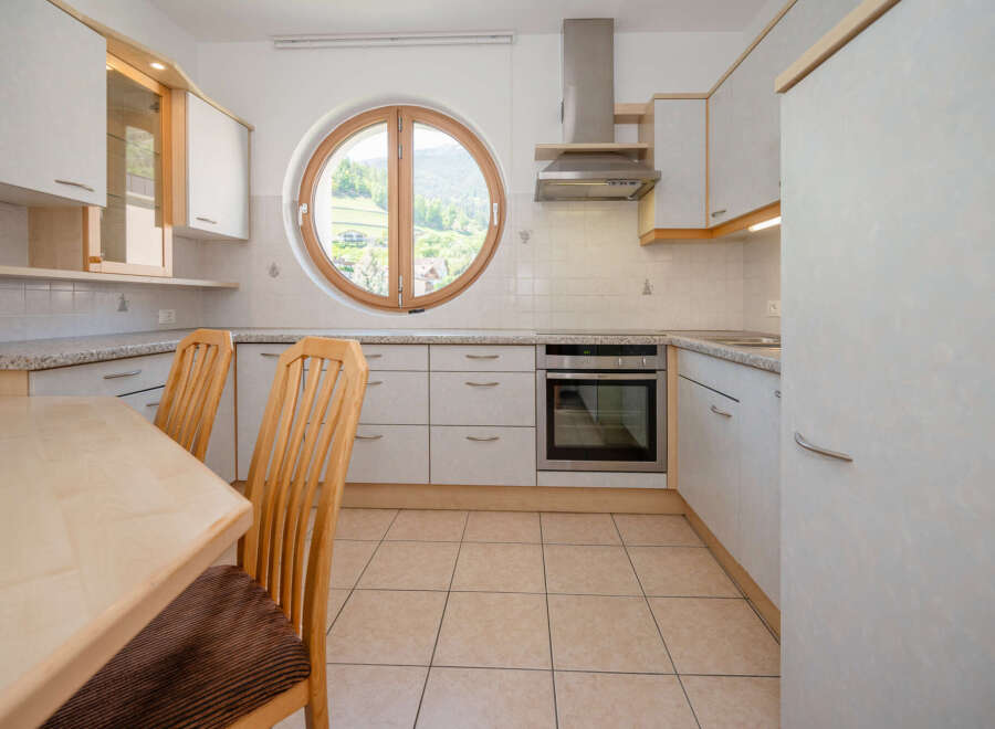 Discover the charm of this inviting kitchen, featuring a unique round window that frames picturesque views.