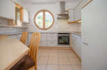 Discover the charm of this inviting kitchen, featuring a unique round window that frames picturesque views.