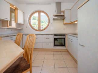 Discover the charm of this inviting kitchen, featuring a unique round window that frames picturesque views.