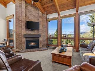 Experience luxury living in this stunning property featuring a cozy fireplace and expansive windows that frame breathtaking views.