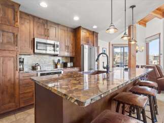 This stunning kitchen boasts custom cabinetry, stainless steel appliances, and a beautiful granite countertop.