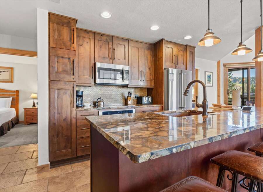 This stunning kitchen boasts custom cabinetry, stainless steel appliances, and a beautiful granite countertop, perfect for preparing meals and entertaining guests.