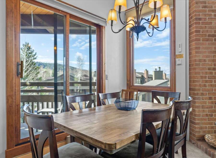 Enjoy breathtaking views from this stunning dining room! This space features a beautiful wooden table, perfect for hosting gatherings.