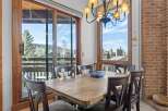 Enjoy breathtaking views from this stunning dining room! This space features a beautiful wooden table, perfect for hosting gatherings.