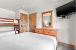 This cozy bedroom features a comfortable bed and a set of bunk beds, perfect for families or groups.