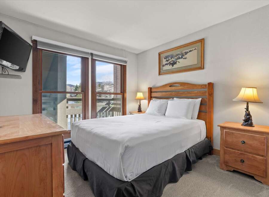 This cozy bedroom features a comfortable bed with crisp white linens and a stylish bed skirt.