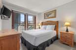 This cozy bedroom features a comfortable bed with crisp white linens and a stylish bed skirt.