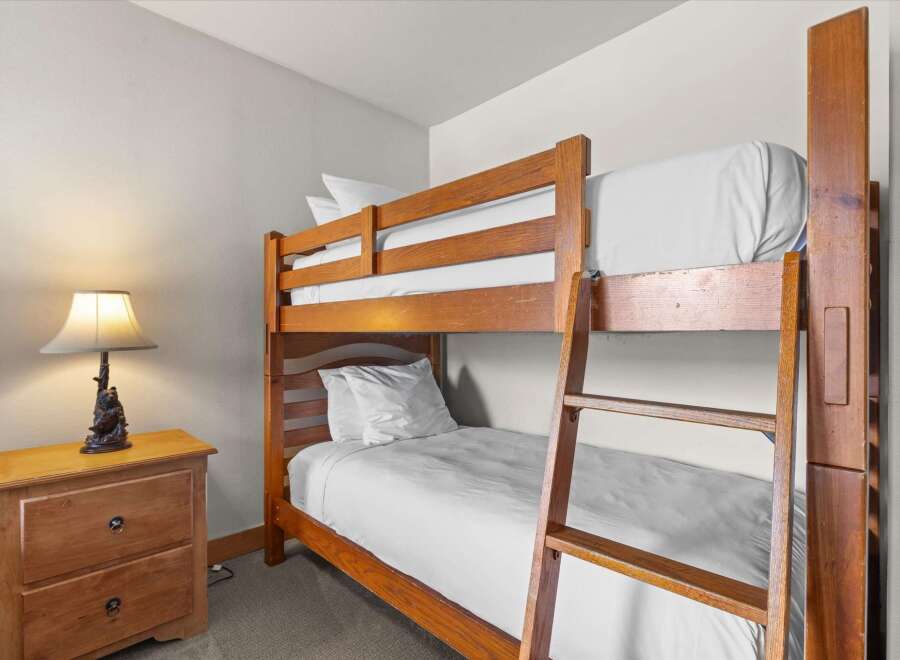 This cozy bedroom features a charming bunk bed, perfect for accommodating guests or family members.