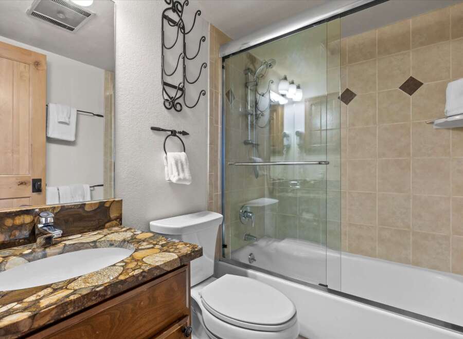 Step into this beautifully designed bathroom, featuring a stylish vanity with a unique countertop and a sleek, modern sink.