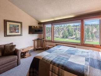Experience the tranquility of this stunning bedroom, featuring a picturesque view of a lush green landscape.