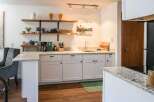 This stunning kitchen boasts a modern design with sleek white cabinetry and granite countertops, creating a bright and inviting space.