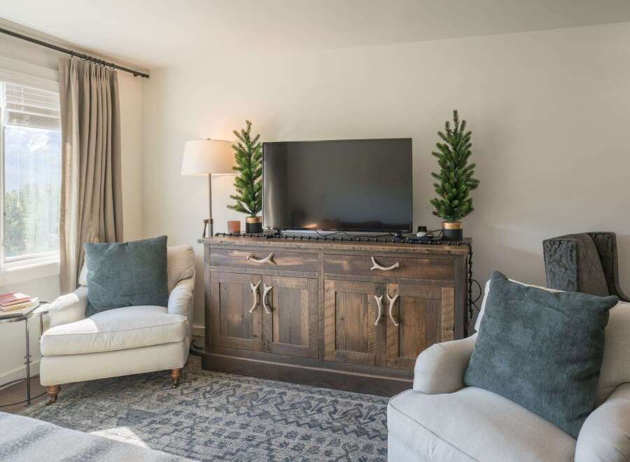 This cozy living room features a rustic wooden cabinet that serves as a stylish entertainment center.