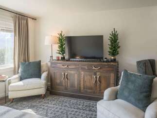 This cozy living room features a rustic wooden cabinet that serves as a stylish entertainment center.