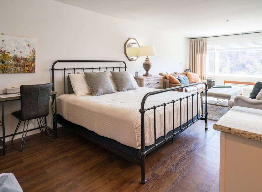 Discover the charm of this inviting bedroom, featuring a stylish wrought iron bed and a cozy ambiance.