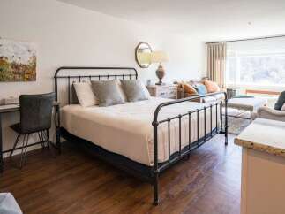 Discover the charm of this inviting bedroom, featuring a stylish wrought iron bed and a cozy ambiance.