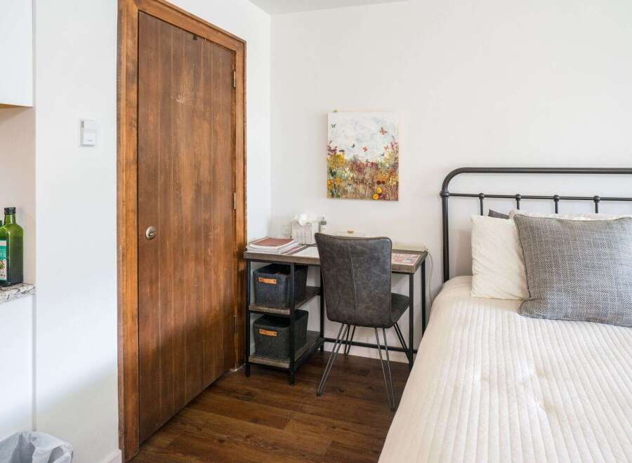 This cozy bedroom features a stylish desk area perfect for work or study.
