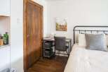 This cozy bedroom features a stylish desk area perfect for work or study.