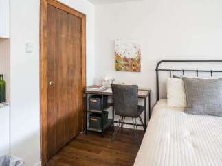 This cozy bedroom features a stylish desk area perfect for work or study.