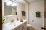 This bathroom features a bright and airy design with a modern vanity and a large mirror.
