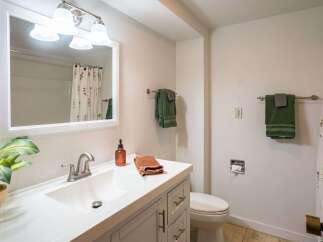 This bathroom features a bright and airy design with a modern vanity and a large mirror.