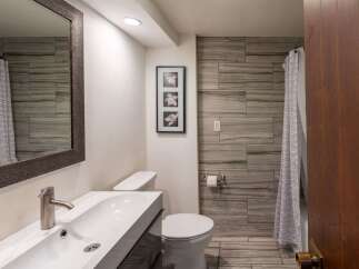 Step into this beautifully designed bathroom, featuring modern fixtures and a stylish aesthetic.