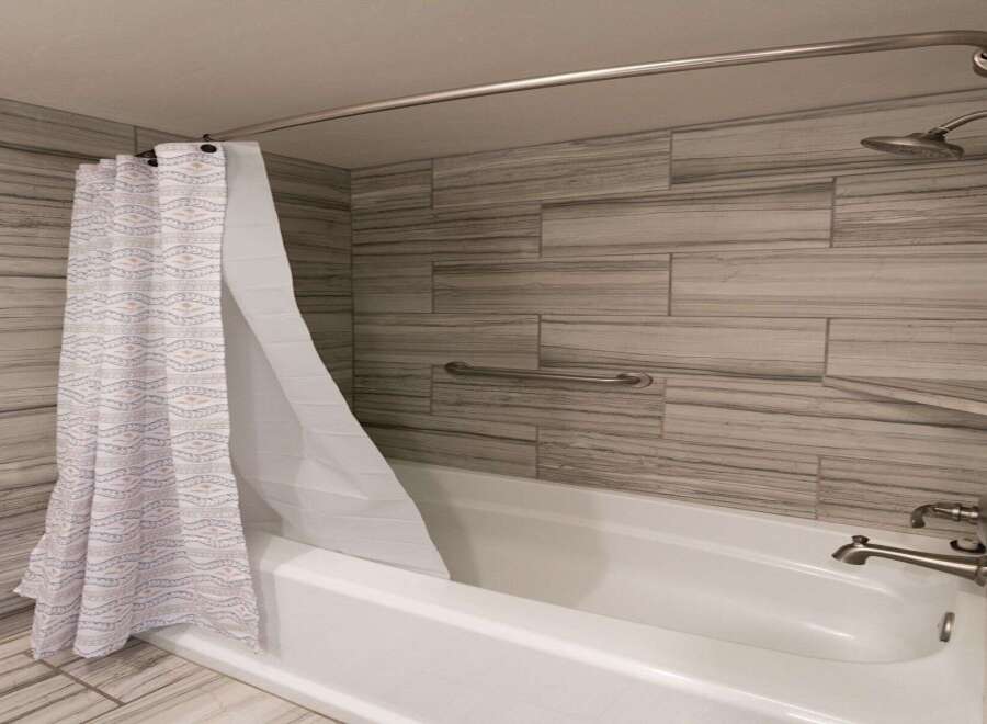 Step into a beautifully designed bathroom featuring a modern shower with a stylish curtain.