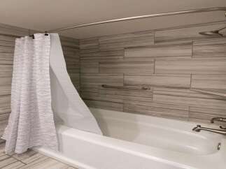 Step into a beautifully designed bathroom featuring a modern shower with a stylish curtain.