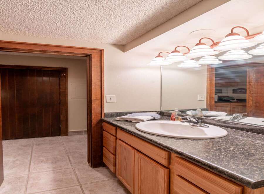 This bathroom features a stylish vanity with ample storage, perfect for keeping your essentials organized.